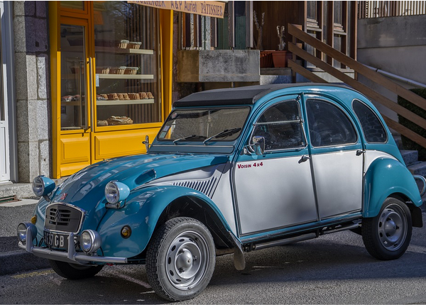 Photo of a Citroen car parked outside a bright yellow shop