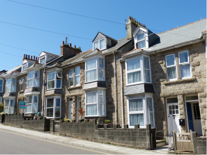 Blue skies, row of pretty grey terraced houses in the sunshine. 