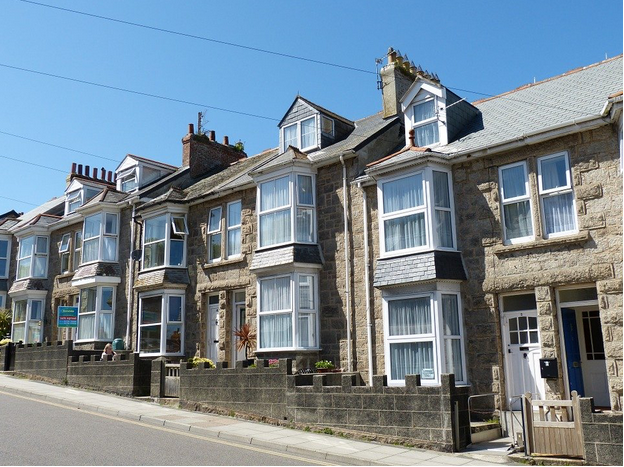 Blue skies, row of pretty grey terraced houses in the sunshine.