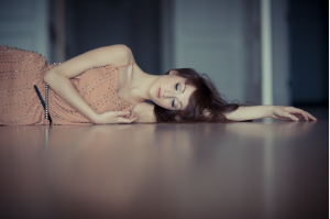Image o f a beautiful lwoman, lying on the floor, dressed glamorously and seemingly asleep