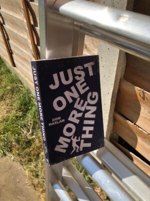 Just One More Thing, an image of the book propped on teh rung of an aluminium ladder 