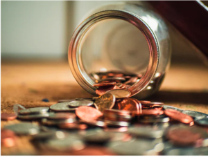 A jar on it's side with coins spilling out 