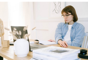 Image of a woman sat at a desk looking at a laptop